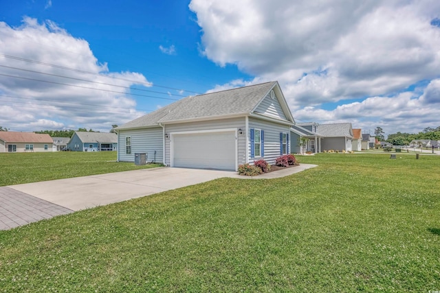 view of front of property with central AC unit, a front yard, and a garage