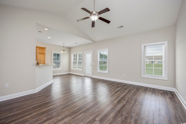 unfurnished living room with ceiling fan with notable chandelier, lofted ceiling, and dark wood-type flooring