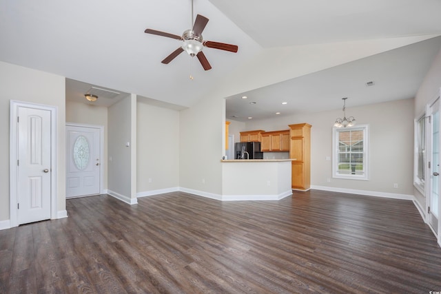 unfurnished living room with ceiling fan with notable chandelier, lofted ceiling, and dark hardwood / wood-style floors