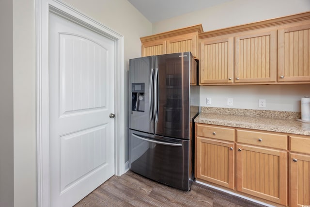 kitchen featuring light brown cabinets, hardwood / wood-style floors, and stainless steel fridge