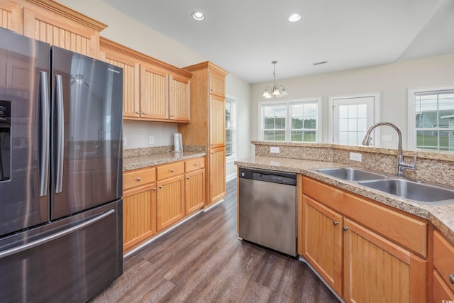 kitchen featuring appliances with stainless steel finishes, a healthy amount of sunlight, dark hardwood / wood-style flooring, and a chandelier