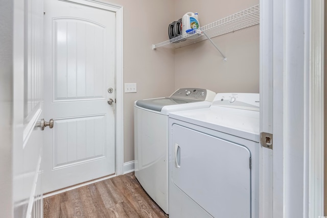 laundry area with light hardwood / wood-style floors and washing machine and dryer