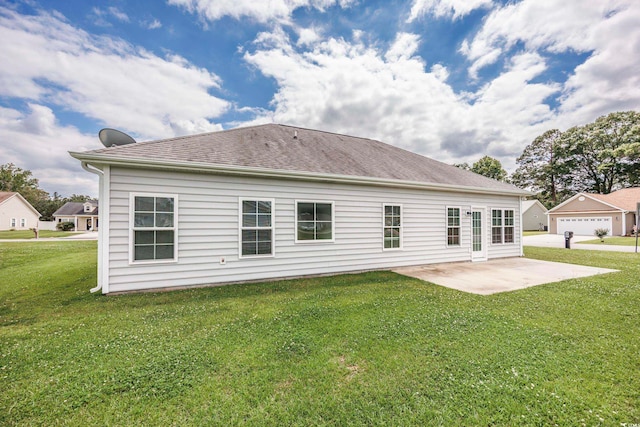 rear view of house featuring a lawn, a patio area, and a garage