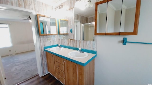 bathroom featuring vanity, ceiling fan, ornamental molding, and walk in shower