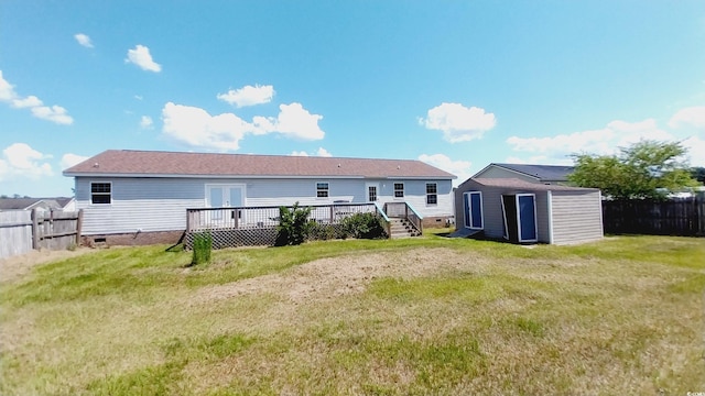 rear view of property featuring a storage unit, a yard, and a deck