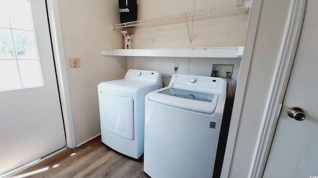 laundry room with independent washer and dryer and hardwood / wood-style flooring