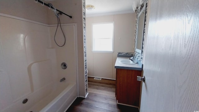 bathroom featuring vanity, hardwood / wood-style floors, crown molding, and shower / bathtub combination