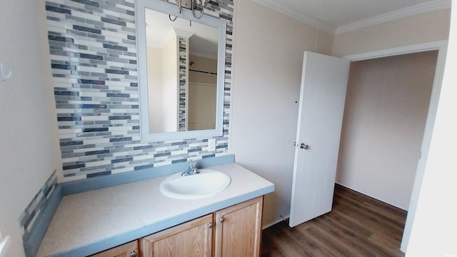 bathroom with vanity, crown molding, decorative backsplash, and wood-type flooring