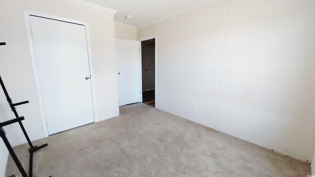 unfurnished bedroom with crown molding and carpet