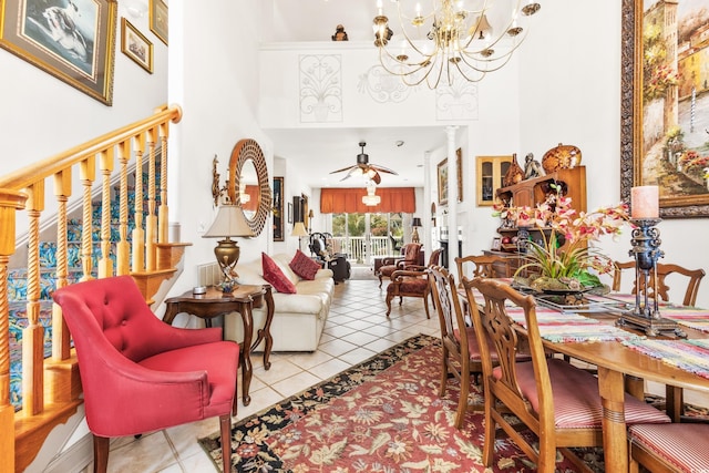 dining room featuring light tile patterned flooring, ceiling fan with notable chandelier, and decorative columns