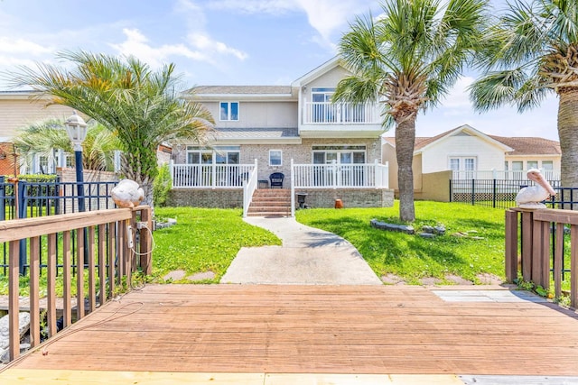 view of front of house with a wooden deck and a front lawn