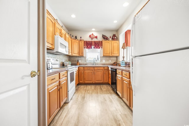 kitchen featuring sink, backsplash, white appliances, and light hardwood / wood-style flooring