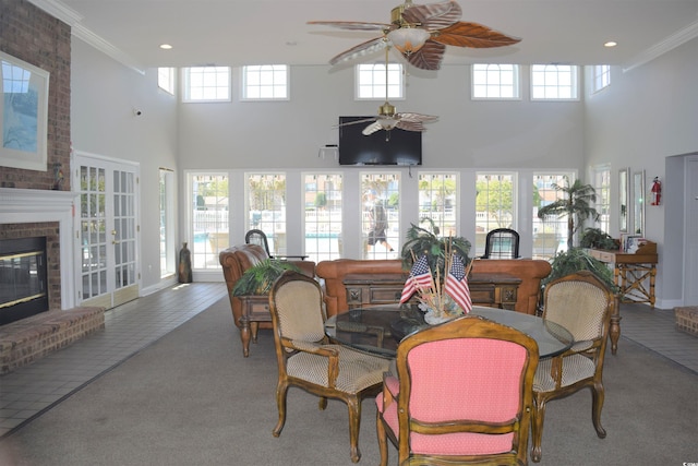 sunroom featuring ceiling fan, a fireplace, and a wealth of natural light