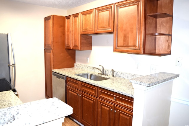 kitchen with light stone countertops, refrigerator, a textured ceiling, sink, and dishwasher