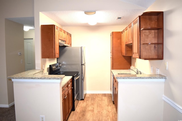 kitchen featuring light wood-type flooring, light stone counters, a textured ceiling, sink, and stainless steel range with electric cooktop