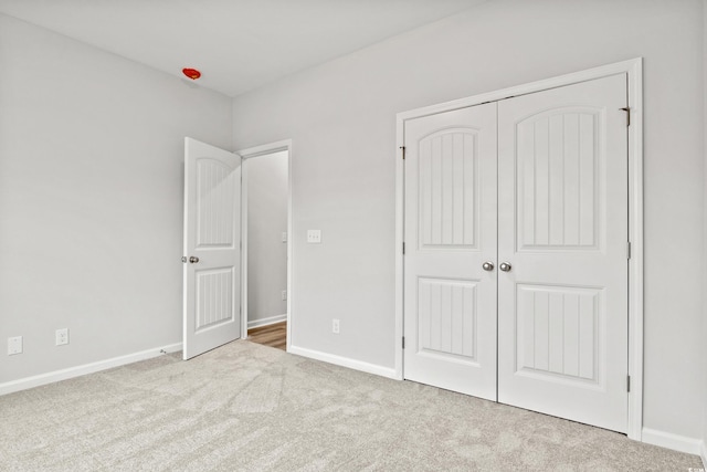 unfurnished bedroom featuring a closet and light carpet