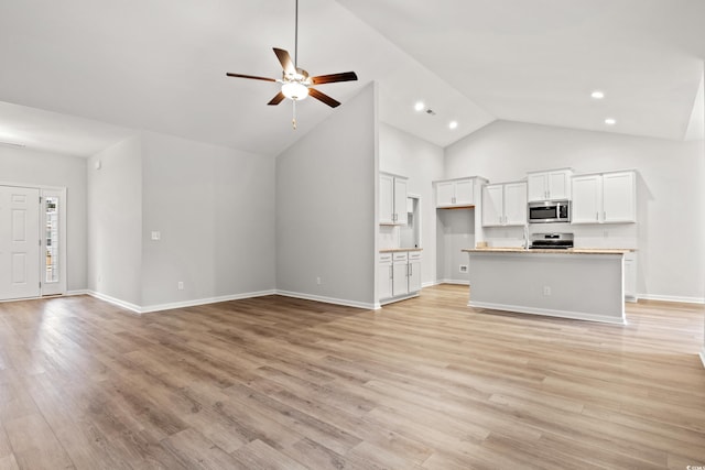 unfurnished living room with ceiling fan, light hardwood / wood-style floors, and high vaulted ceiling