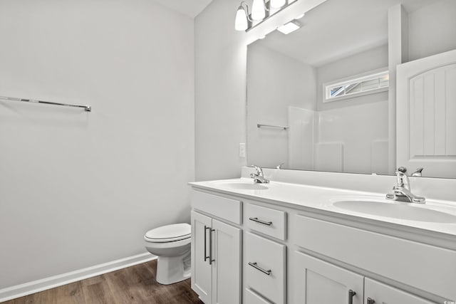 bathroom with toilet, vanity, and hardwood / wood-style flooring