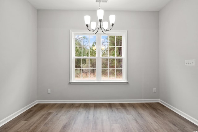 unfurnished dining area featuring hardwood / wood-style flooring and a notable chandelier