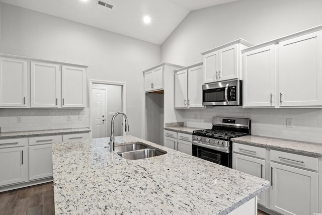 kitchen with high vaulted ceiling, white cabinets, sink, and stainless steel appliances