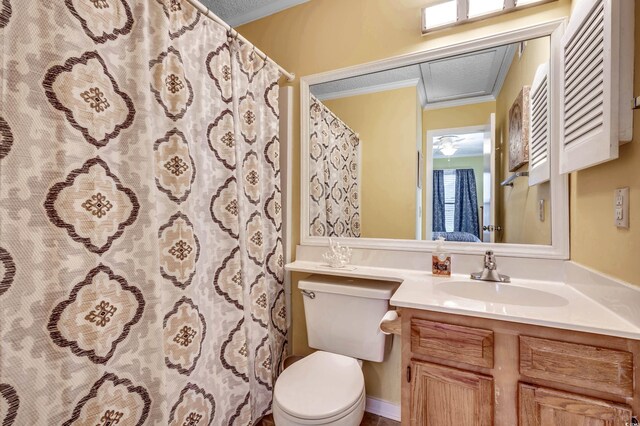 bathroom featuring vanity, toilet, ornamental molding, and a textured ceiling