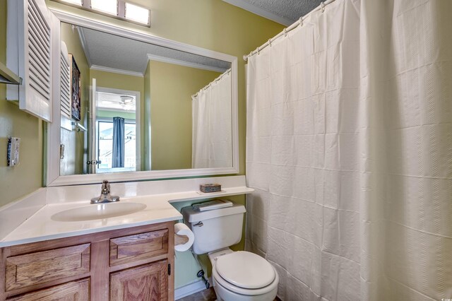 bathroom featuring toilet, vanity, a textured ceiling, and ornamental molding