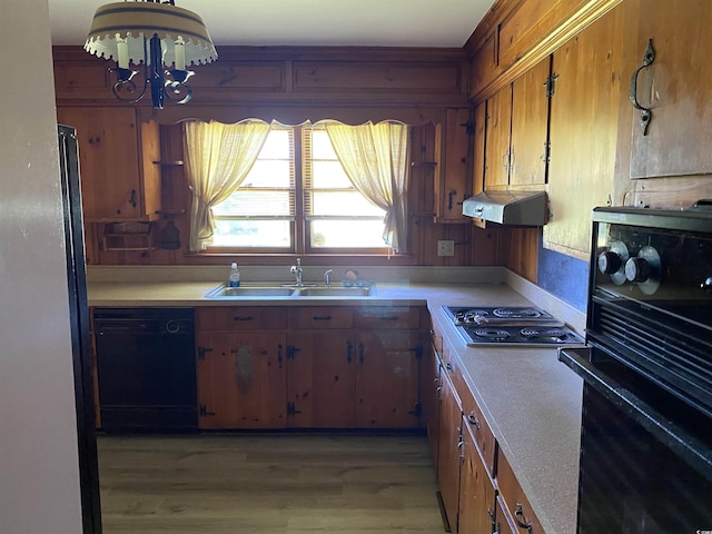 4155 Pinewood Dr, Mullins, SC 29574 - kitchen with sink, an inviting chandelier, black appliances, and light hardwood / wood-style flooring