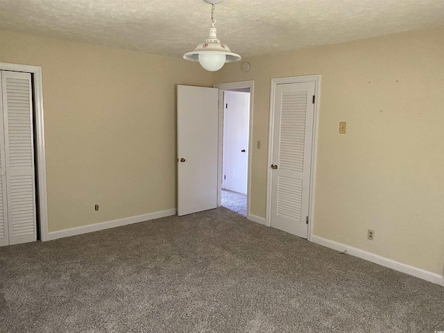 4155 Pinewood Dr, Mullins, SC 29574 - unfurnished bedroom featuring carpet, a textured ceiling, and multiple closets