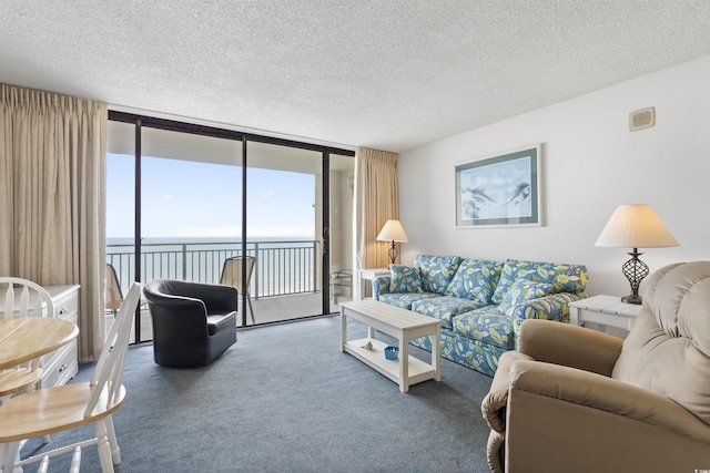 living room with a textured ceiling, a water view, dark carpet, and expansive windows