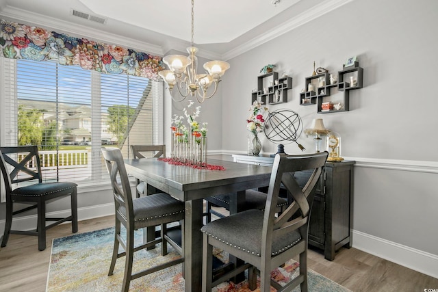 dining area featuring ornamental molding, a chandelier, and light hardwood / wood-style floors