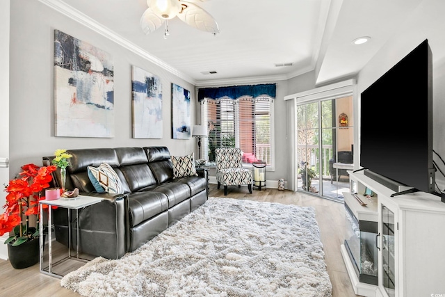 living room with light hardwood / wood-style flooring, ornamental molding, and ceiling fan