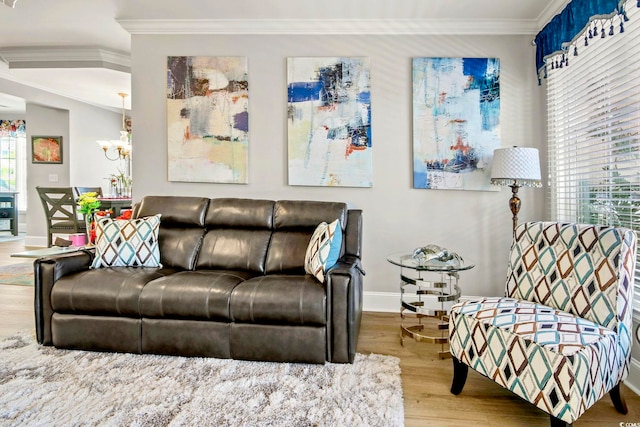 living room featuring crown molding, wood-type flooring, and a chandelier