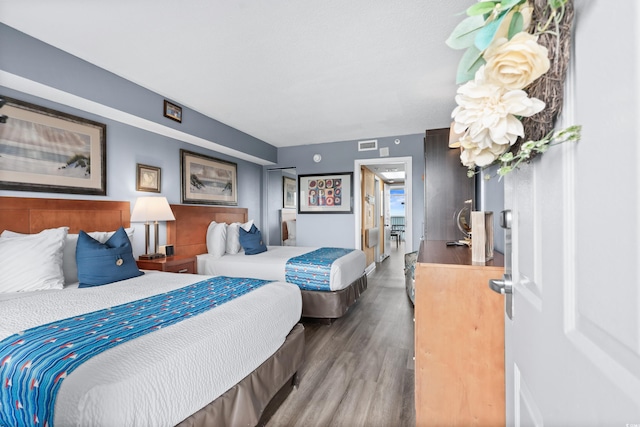 bedroom featuring visible vents and wood finished floors