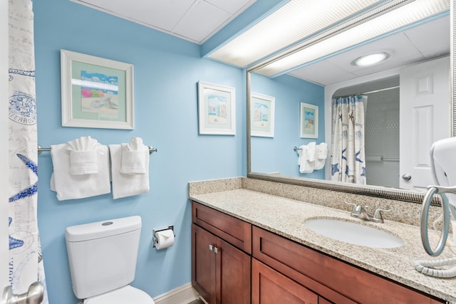 bathroom featuring curtained shower, toilet, and vanity