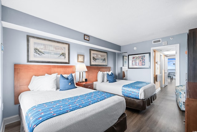 bedroom with visible vents, baseboards, and wood finished floors