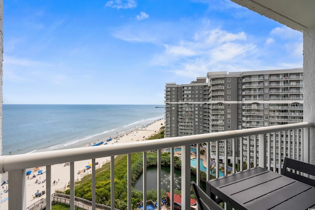 balcony featuring a view of the beach and a water view