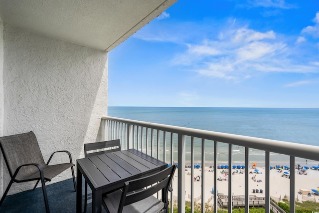 balcony featuring a beach view and a water view