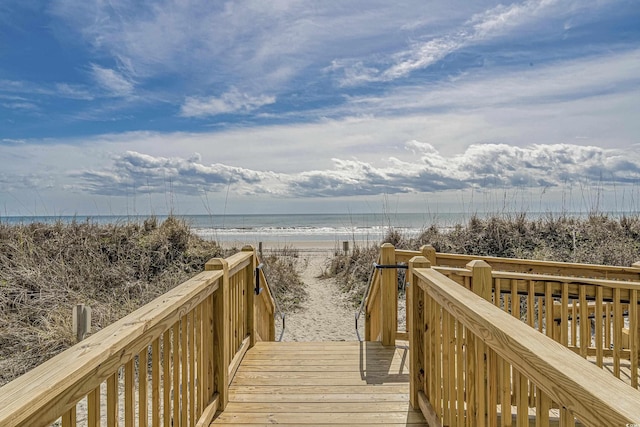 view of home's community featuring a deck with water view and a view of the beach