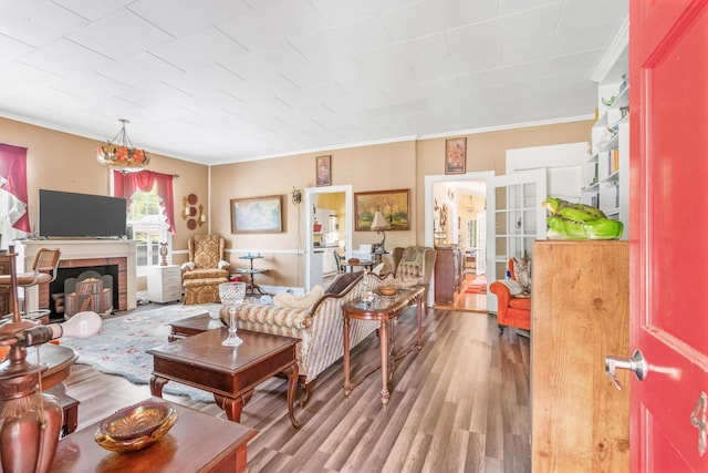 living room with a fireplace, light hardwood / wood-style floors, and crown molding