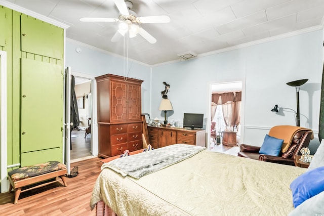 bedroom featuring ceiling fan, crown molding, and light hardwood / wood-style floors