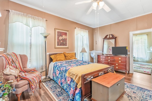 bedroom featuring ceiling fan, ornamental molding, and light hardwood / wood-style flooring