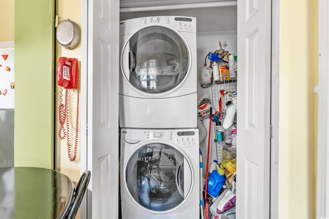 clothes washing area with stacked washing maching and dryer