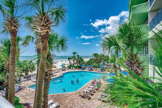 view of pool featuring a patio area and a water view