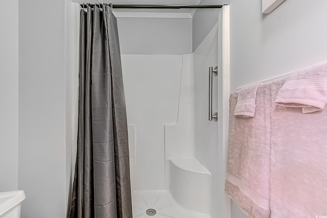 full bathroom with toilet and a shower with shower curtain