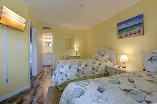 bedroom with connected bathroom, wood finished floors, visible vents, baseboards, and crown molding