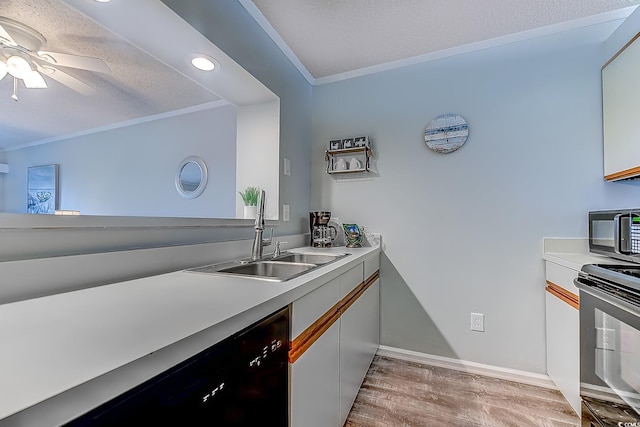 kitchen featuring light wood-style flooring, light countertops, crown molding, black appliances, and a sink