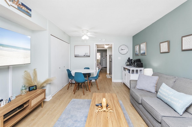 living room with ceiling fan and light hardwood / wood-style flooring