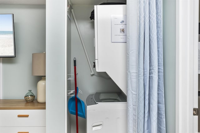 clothes washing area with stacked washer / dryer