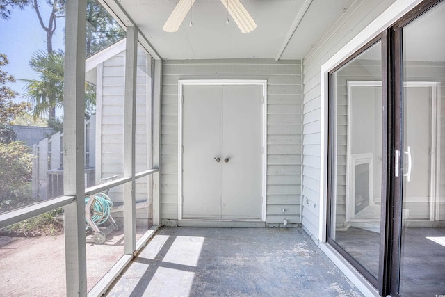 unfurnished sunroom with ceiling fan