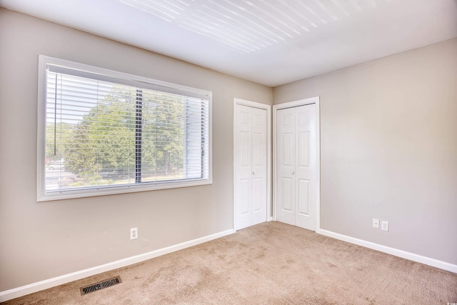 unfurnished bedroom featuring light carpet